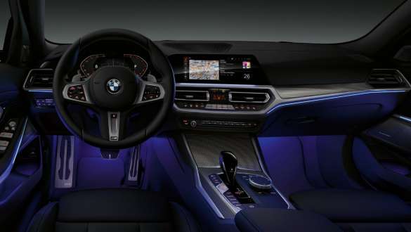 BMW 3 Series Sedan (G20), Ambient light. Front view of the driver's cockpit of the BMW 3 Series Sedan (G20) with by Ambient light blue illuminated legroom.