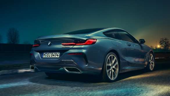 Exhaust tailpipes and rear wheels. G15 BMW 8 Series Coupé, low rear view, exhaust tailpipes and rear wheels. G15