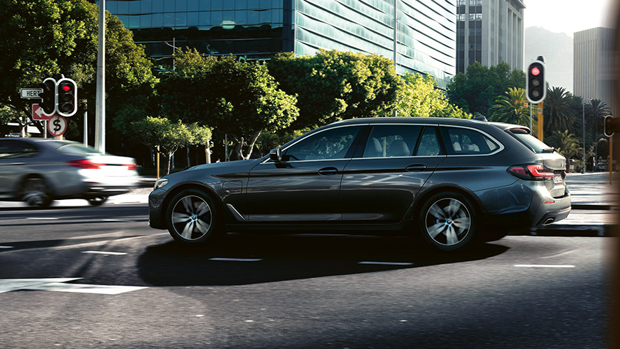 BMW 530e Touring G31 LCI in Sophisto grey metallic, driving in city traffic BMW 530e Touring G31 LCI in Sophisto grey metallic, driving in city traffic