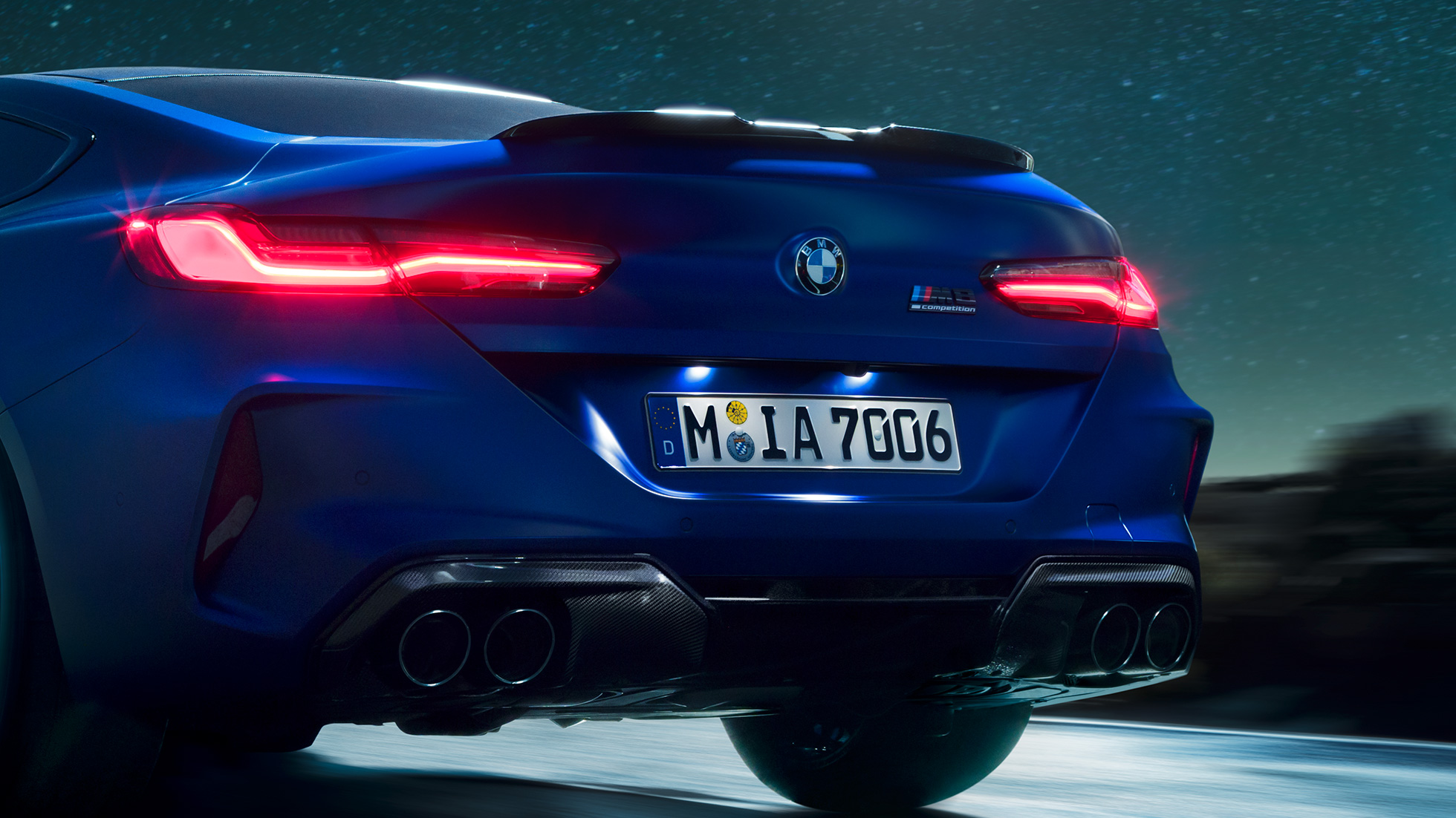M diffuser in Carbon Black. F92 BMW M8 Competition Coupé in Marina Bay Blue metallic, close-up rear at night with M diffuser in Carbon Black. F92