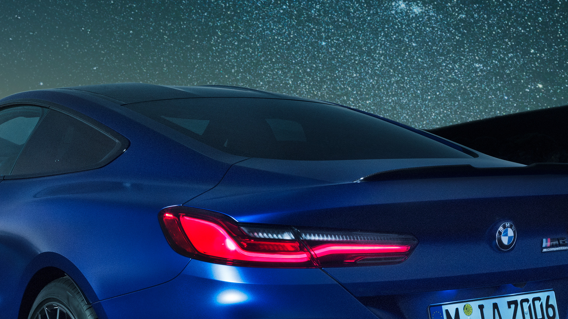 M rear spoiler F92 BMW M8 Competition Coupé in Marina Bay Blue metallic, nightly close-up of shoulder section with M rear spoiler in Carbon. F92
