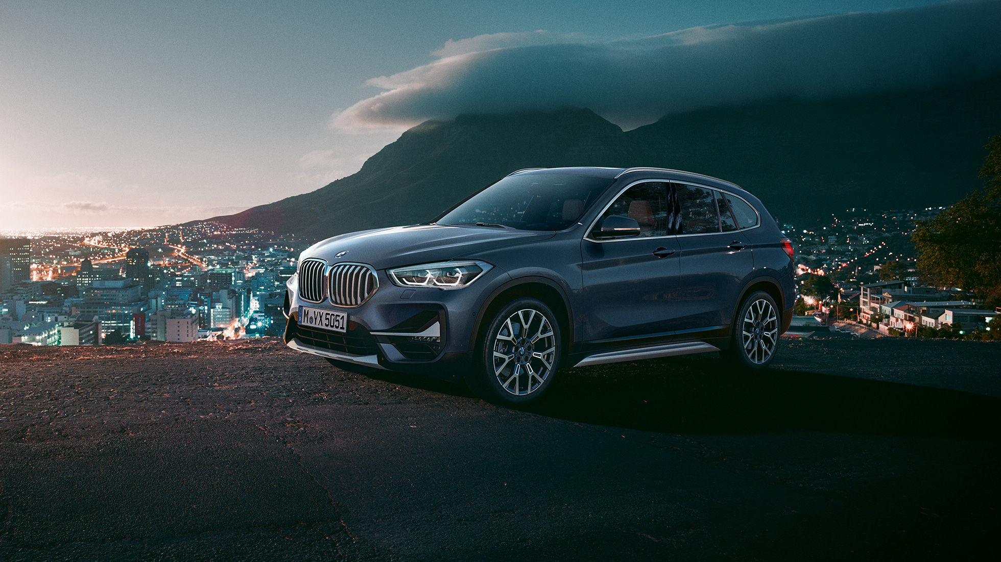 BMW X1, three-quarter side view. F48 BMW X1, three-quarter side view standing in front of urban scenery. F48