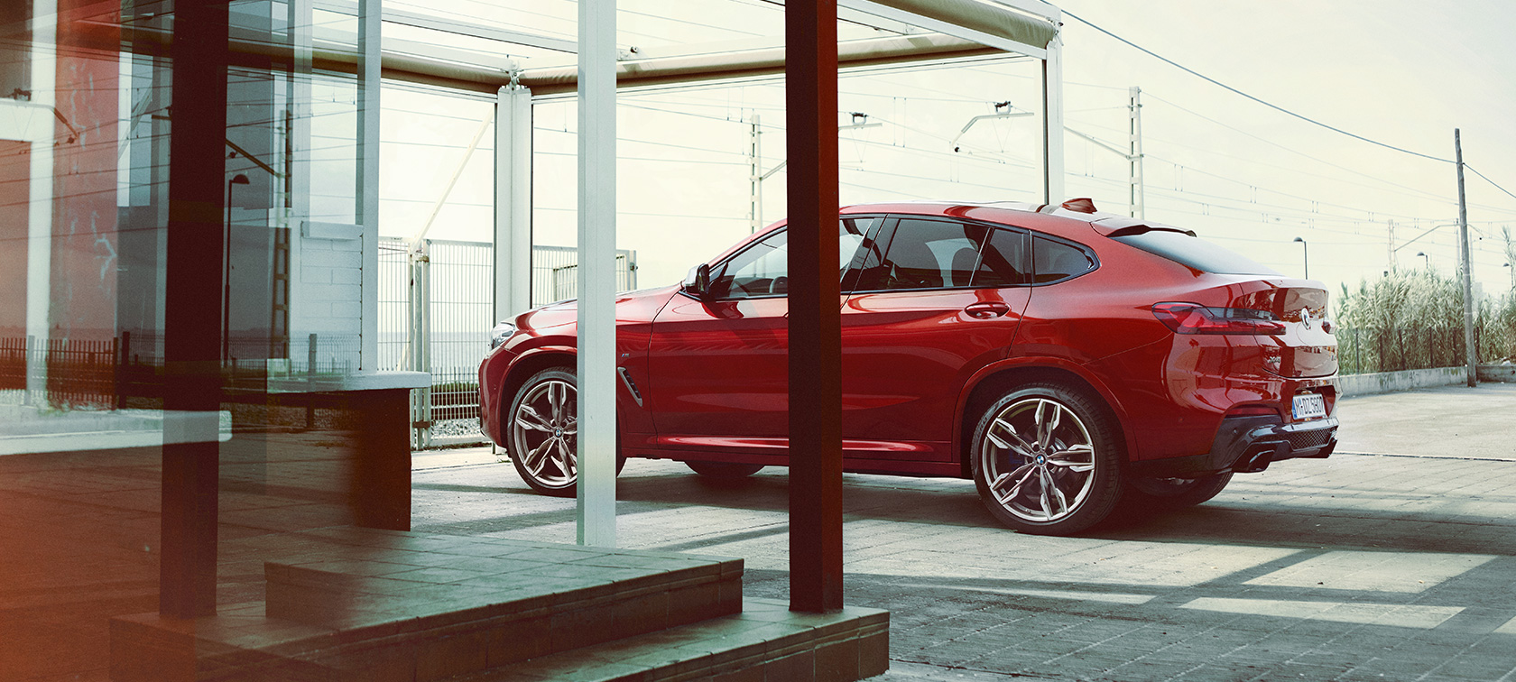 BMX X4 side view G02 BMW X4 M40i G02 2018 Flamenco Red brilliant effect side view parking