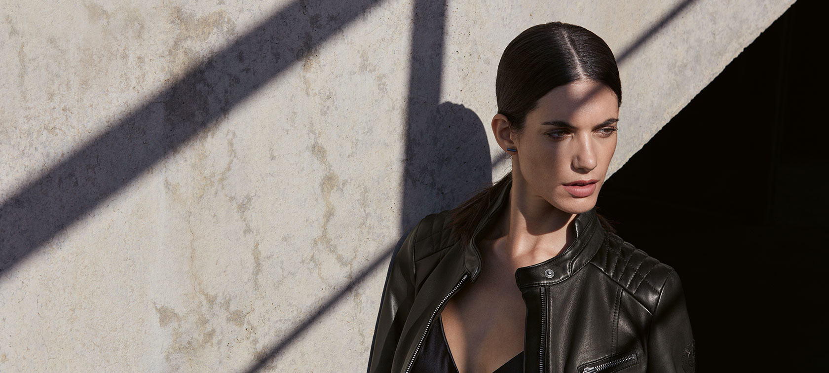 In the picture, a young woman is wearing the BMW Ladies Leather Jacket in front of an urban backdrop. In the picture, a young woman is wearing the BMW Ladies Leather Jacket in front of an urban backdrop.