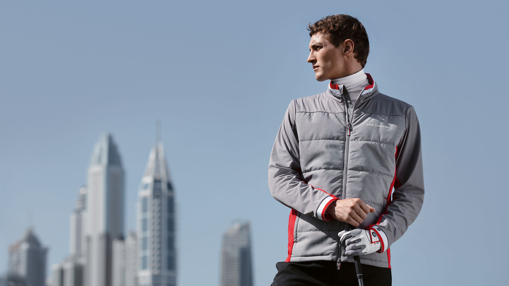 In the picture, a man presents articles from the BMW Golfsport Collection against the backdrop of a big city skyline. In the picture, a man presents articles from the BMW Golfsport Collection against the backdrop of a big city skyline.