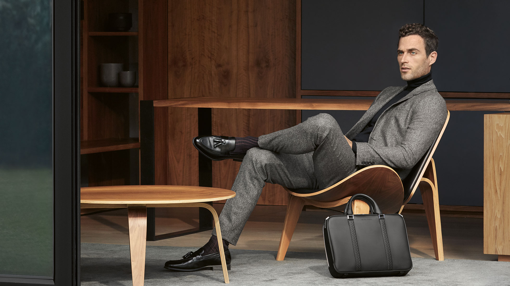 The Collection. In the picture, a seated man wearing a suit presents articles from The Collection.