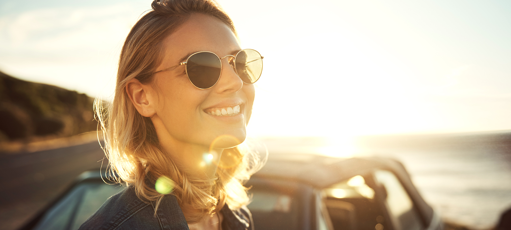 Original BMW Accessories Original BMW Accessories: woman wears sun glasses and smiles, BMW in the background