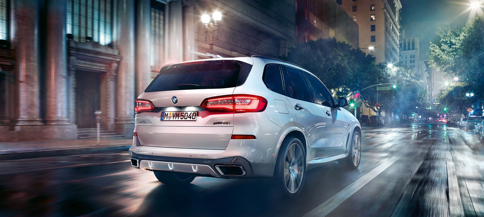 BMW X5 three-quarter rear view driving BMW X5 G05 2018 Mineral White metallic three-quarter rear view driving