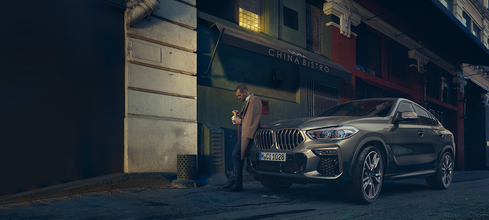 BMW X6 three-quarter rear view driving BMW X6 G06 2019 Manhatten metallic three-quarter rear view driving